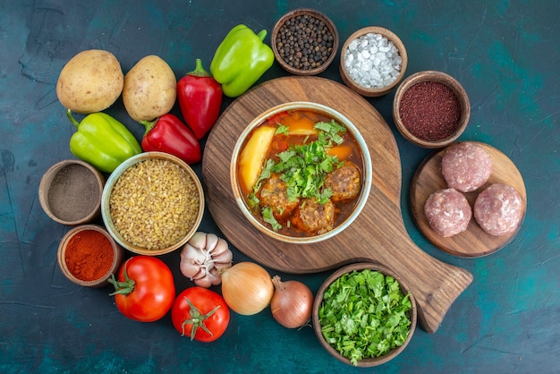 Top view delicious soup with fresh vegetables and greens on dark-blue desk vegetable ripe food meal meat soup