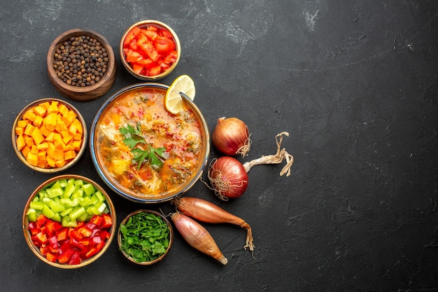 Vista dall'alto deliziosa zuppa con verdure e verdure su uno spazio grigio