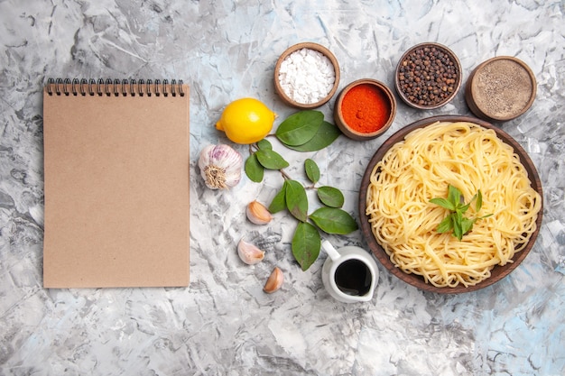 Top view delicious spaghetti with seasonings on light white table dinner pasta dough meal