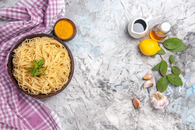 Top view delicious spaghetti with seasonings on light white table pasta meal dough dish