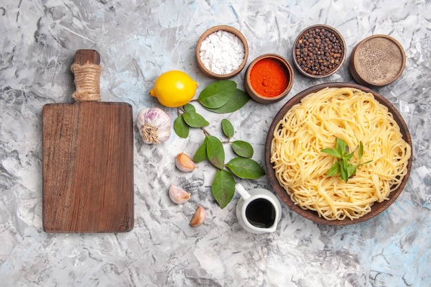 Top view delicious spaghetti with seasonings on white table dinner pasta dough