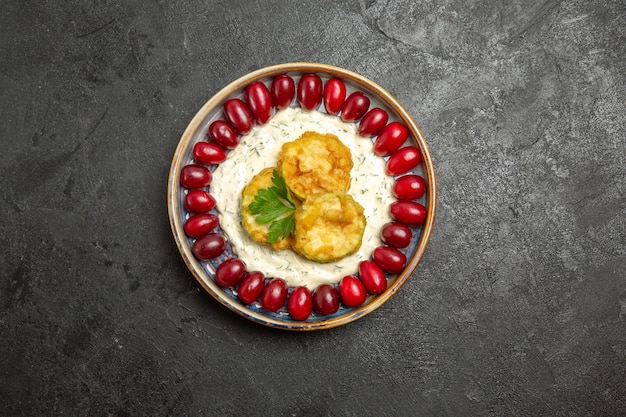 Free photo top view of delicious squash meal with fresh red dogwoods on a grey surface