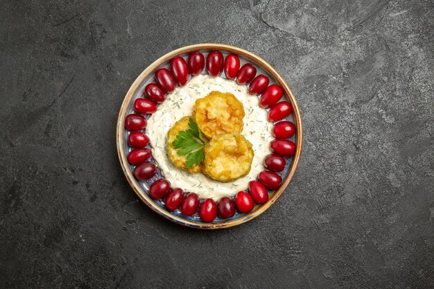 Top view of delicious squash meal with fresh red dogwoods on a grey surface