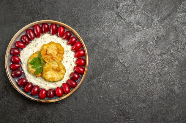 Top view of delicious squash meal with fresh red dogwoods on grey surface