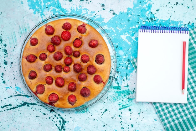 Free photo top view of delicious strawberry cake round shaped with fruits on top and inside on-blue, cake dough sweet biscuit