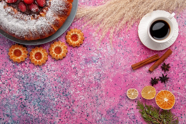 Вид сверху вкусный клубничный торт сахарной пудры торт с печеньем и чашкой чая на розовом фоне торт сладкое сахарное печенье пирог
