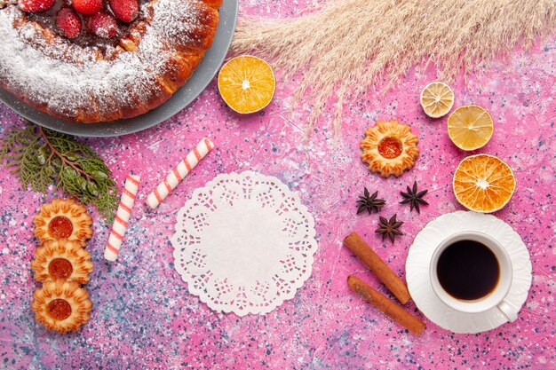 Top view delicious strawberry cake sugar powdered cake with cookies and cup of tea on the pink desk cake sweet sugar cookies pie