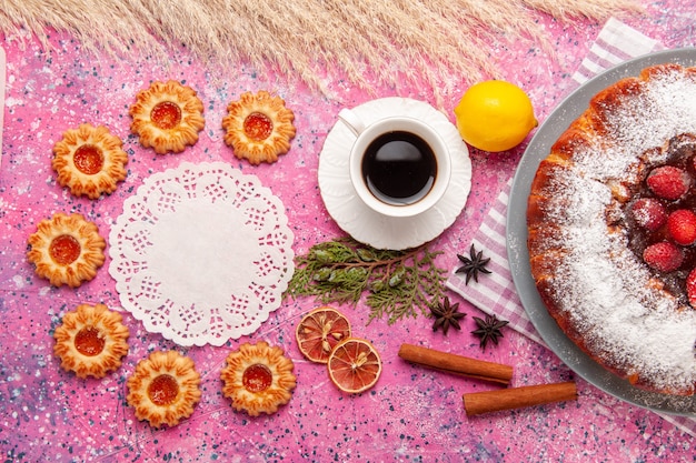 Вид сверху вкусный клубничный торт сахарная пудра с печеньем лимон и чай на розовом фоне торт сладкое сахарное печенье печенье чай