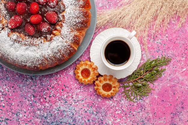 Вид сверху вкусный клубничный торт с печеньем и чашкой чая на розовом фоне торт сладкое сахарное печенье выпечка пирога
