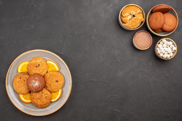 Vista dall'alto deliziosi biscotti di zucchero con arance fresche a fette su sfondo scuro biscotto frutta zucchero biscotto dolce