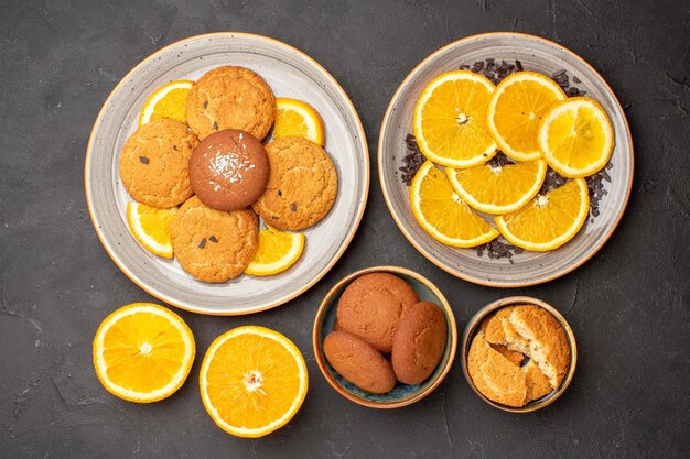어두운 배경 설탕 비스킷 달콤한 쿠키 과일 케이크에 신선한 슬라이스 오렌지와 상위 뷰 맛있는 설탕 쿠키