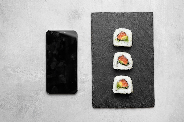 Foto gratuita vista dall'alto delizioso sushi e smartphone