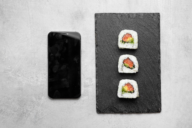 Вид сверху вкусные суши и смартфон