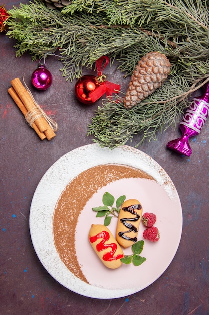 Top view delicious sweet biscuits with christmas toys on dark background cookies sweet biscuit sugar color cake