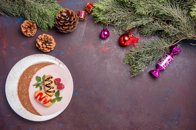 어두운 배경 쿠키 달콤한 비스킷 설탕 색 케이크에 크리스마스 장난감과 나무와 상위 뷰 맛있는 달콤한 비스킷