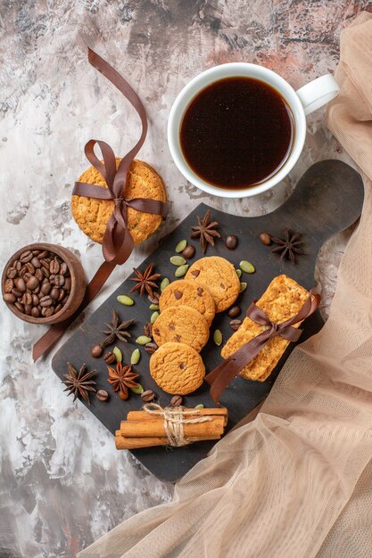 Вид сверху вкусного сладкого печенья с кофейными семечками и чашкой кофе на светлом фоне, сахарное чайное печенье, цвет сладкого какао-торта