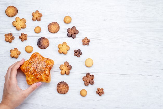 軽いクッキービスケットの甘い砂糖で焼いたペストリーと一緒に形成されたさまざまなおいしい甘いクッキーの上面図
