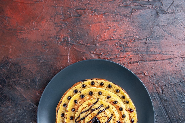 Foto gratuita vista dall'alto deliziose frittelle dolci con glassa sulla superficie scura