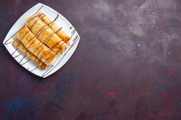 Top view delicious sweet pastries inside plate on dark purple space