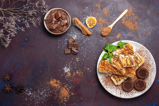 暗い空間にチョコレートクッキーとトップビューのおいしい甘いペストリー