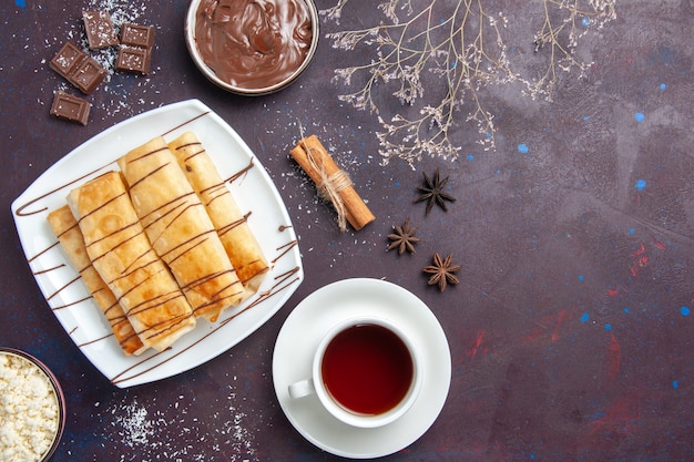 暗い空間にチョコレートとお茶のトップビューおいしい甘いペストリー