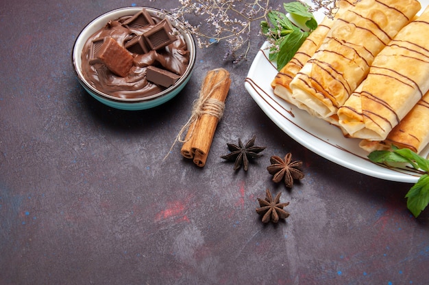 Free photo top view delicious sweet pastries with chocolate on dark space