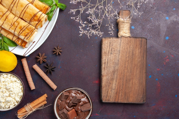 Вид сверху вкусной сладкой выпечки с лимоном на темном пространстве