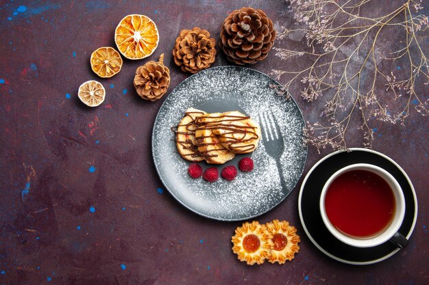 Top view delicious sweet rolls sliced cake for cup of tea on a dark background roll biscuit sweet pie cake tea dessert