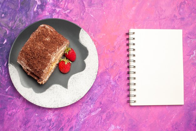 Top view of delicious sweet rolls with strawberries on pink surface