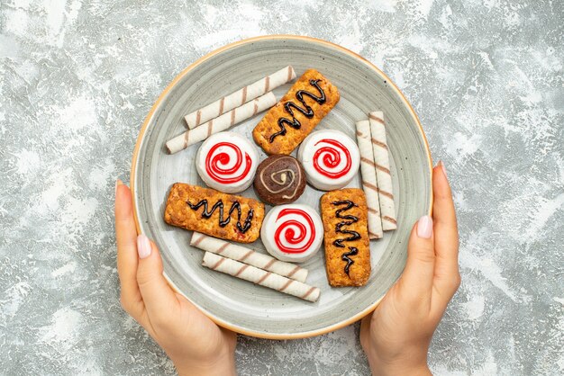 Vista dall'alto deliziosi dolci torte e biscotti su uno spazio bianco