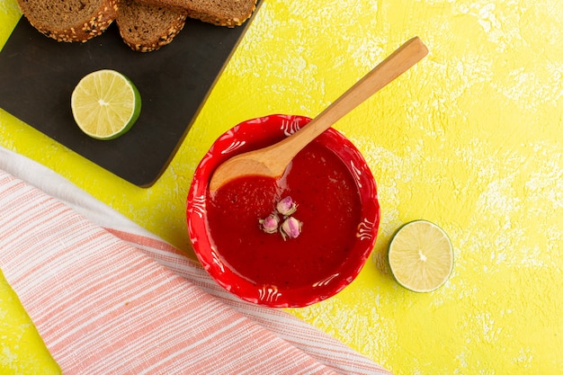 Vista dall'alto deliziosa salsa di pomodoro con limone e pagnotte di pane sul cibo vegetale pasto giallo zuppa di tabella