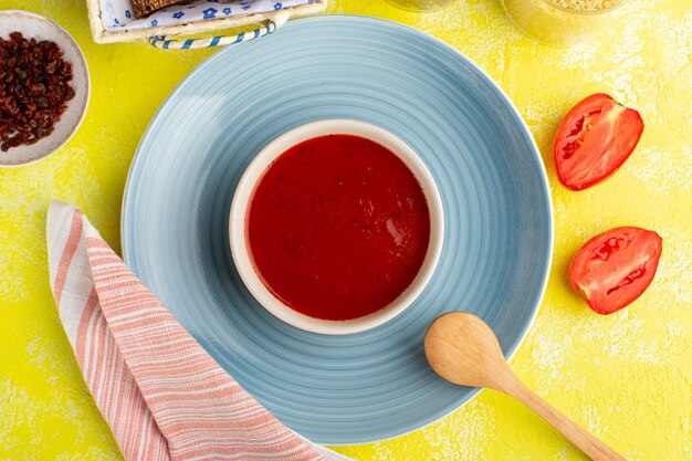 Вид сверху вкусный томатный суп со свежими помидорами на желтом столе, еда, ужин, суп, цвет