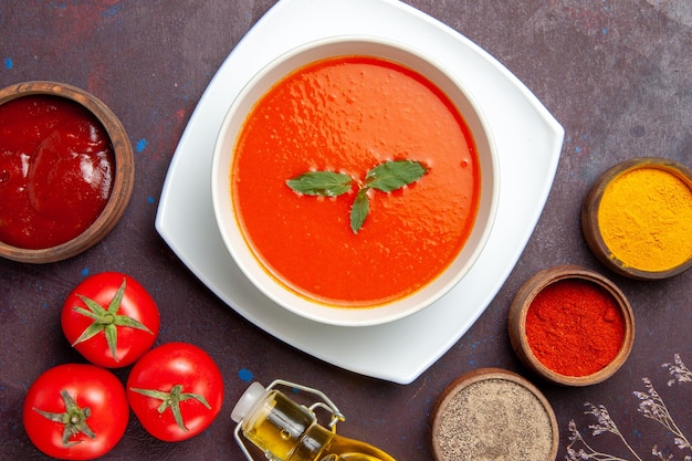 Top view delicious tomato soup with seasonings on a dark background dish sauce tomato color meal soup