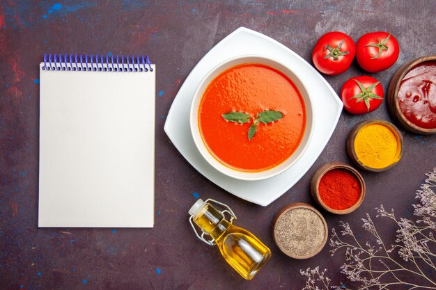 Top view delicious tomato soup with seasonings on dark floor dish sauce tomato color meal soup