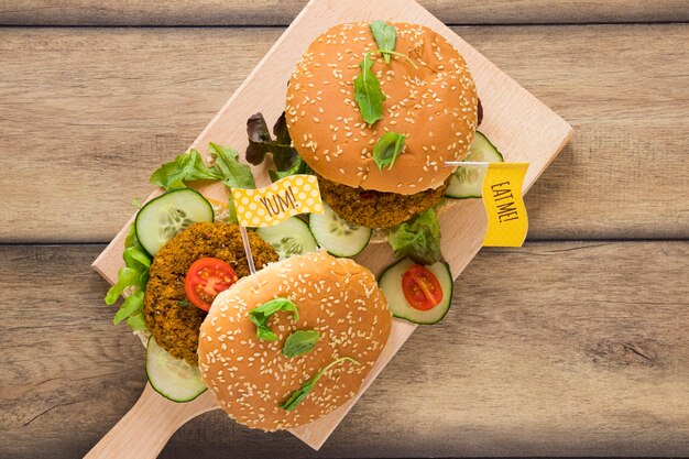 Top view delicious vegan burgers on wooden board