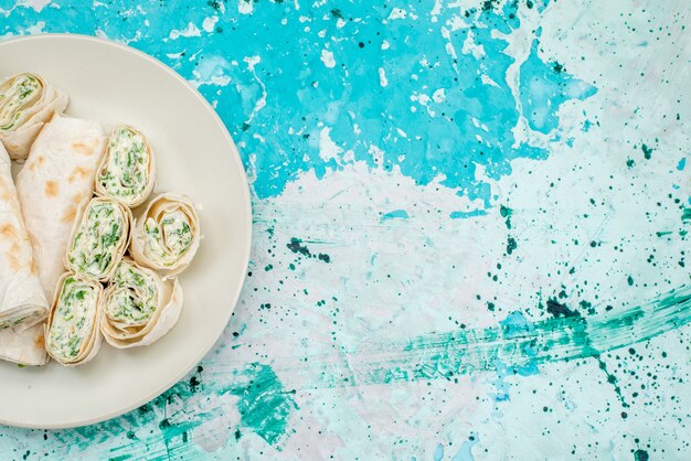 Top view of delicious vegetable rolls whole and sliced on bright-blue desk, food meal roll vegetable snack