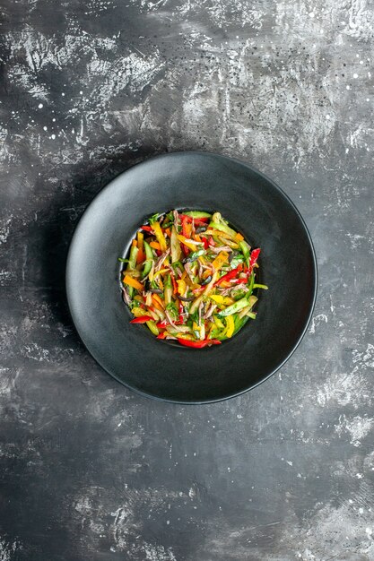 Top view delicious vegetable salad inside plate on a grey background