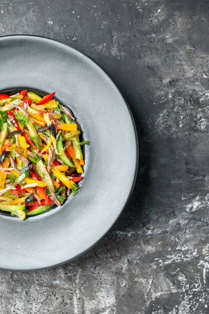 Top view delicious vegetable salad inside plate on grey background