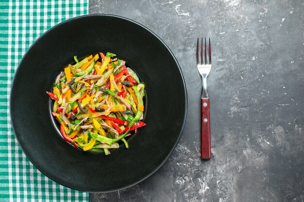 Вид сверху вкусный овощной салат внутри тарелки на сером фоне