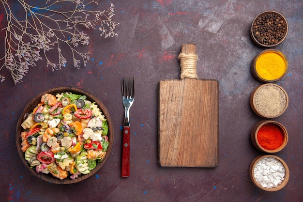 Top view delicious vegetable salad with different seasonings on dark background health diet vegetables salad lunch