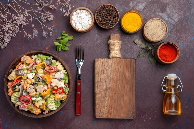 Top view delicious vegetable salad with different seasonings on dark background health vegetable salad diet lunch