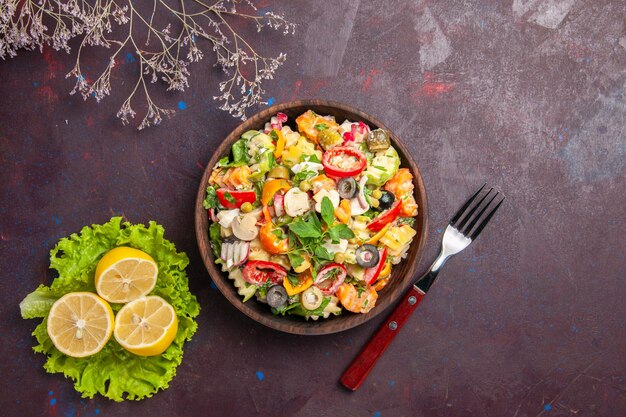 レモンスライスと暗い背景のサラダ食事健康ダイエットの緑のサラダとトップビューおいしい野菜サラダ