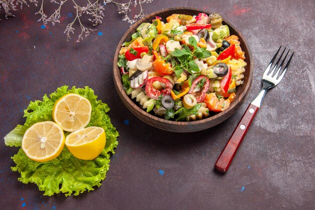 Top view delicious vegetable salad with lemon slices and green salad on dark background salad meal health diet