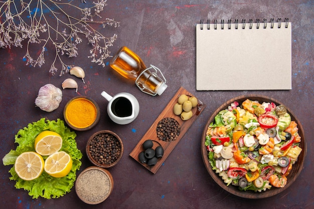 Вид сверху вкусный овощной салат с нарезанными помидорами, оливками и грибами на темном фоне еда диета здоровое питание салат