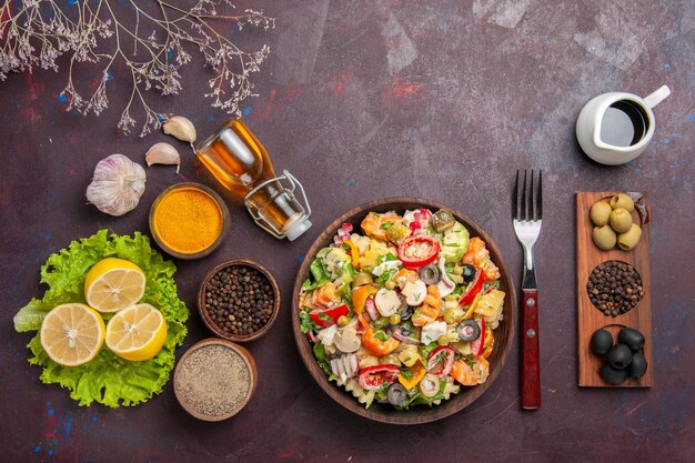 Вид сверху вкусный овощной салат с нарезанными помидорами оливками и грибами на темном столе диетический салат здоровое питание