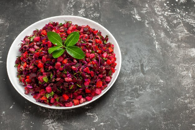 Вид сверху вкусный салат из свеклы винегрет с фасолью на темной поверхности