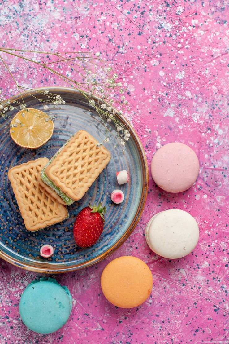Free Photo top view of delicious waffles with yummy french macarons on the pink surface