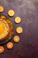 Free photo top view delicious yellow cake creamy dessert with cookies on the dark desk