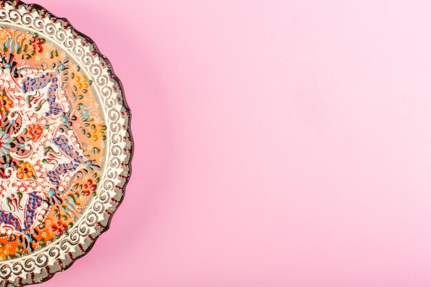 A top view designed empty plate painted glass made plate for meal on pink