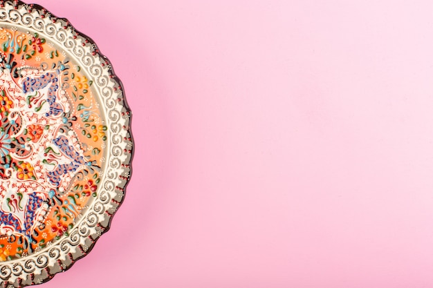 Вид сверху на пустую тарелку, окрашенную стеклянную тарелку для еды на розовом